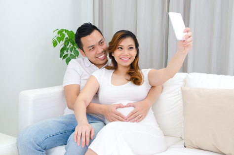 Expectant couple taking selfie