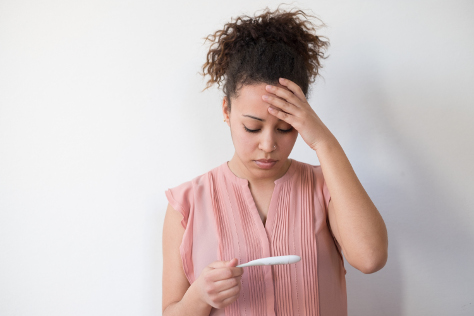 Woman looking worried at pregnancy test