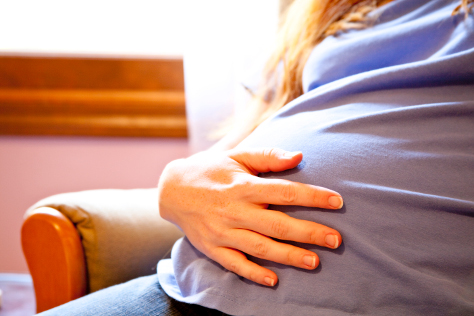Pregnant woman hand on her bump