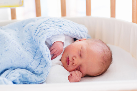 Baby in cot with cot bumper