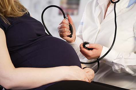 Pregnant woman having blood pressure check 474