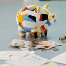 An image of a piggy bank and allowance money on a table