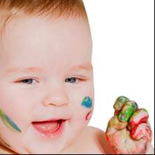A baby playing with fingerpaint